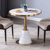 時尚圓形大理石小圓桌搭配兩張皮革餐椅,白色桌面、金色/黑色底座,適合咖啡廳與現代居家使用。
英文:Modern round marble bistro table with white top and gold/black pedestal base, paired with two leather dining chairs.