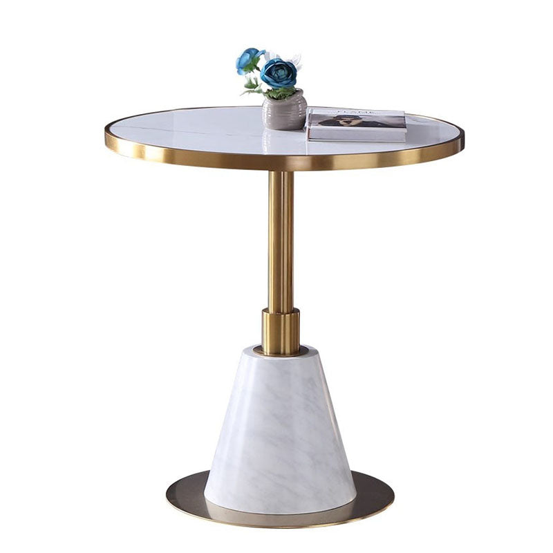 時尚圓形大理石小圓桌搭配兩張皮革餐椅,白色桌面、金色/黑色底座,適合咖啡廳與現代居家使用。Modern round marble bistro table with white top and gold/black pedestal base, paired with two leather dining chairs.