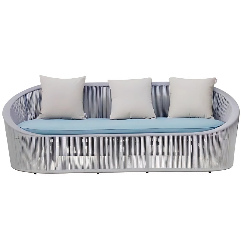 北歐風格灰色藤編戶外休閑沙發，搭配淺藍色座墊和米色靠枕，圓弧形鋁合金框架設計，適合露台花園使用的防水防曬時尚傢俬。Nordic style gray rattan outdoor leisure sofa with light blue cushions and beige pillows, curved aluminum frame design, waterproof furniture ideal for terrace and garden use.