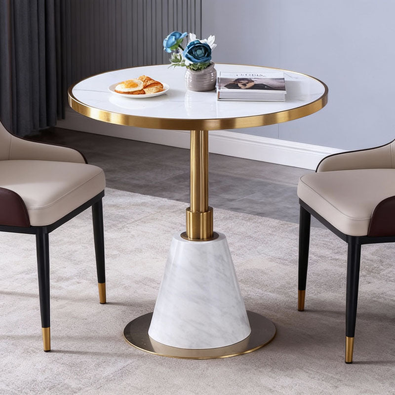 時尚圓形大理石小圓桌搭配兩張皮革餐椅，白色桌面、金色/黑色底座，適合咖啡廳與現代居家使用。
英文：Modern round marble bistro table with white top and gold/black pedestal base, paired with two leather dining chairs.
